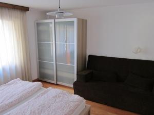 een slaapkamer met een bank en een glazen kast bij Apartment Lauber, Haus Wichje A, Zermatt in Zermatt +3 foto's
