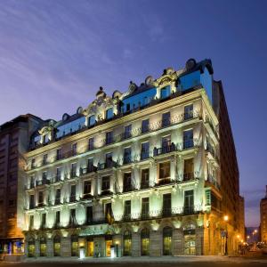 un edificio iluminado en una ciudad por la noche en NH Collection Vigo, en Vigo