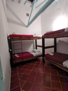 a room with three bunk beds in a room at Hostel Once Once in Villa de Leyva