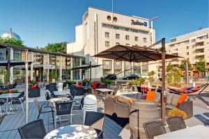 
a patio area with tables, chairs and umbrellas at Radisson Blu Royal Hotel, Helsinki in Helsinki
