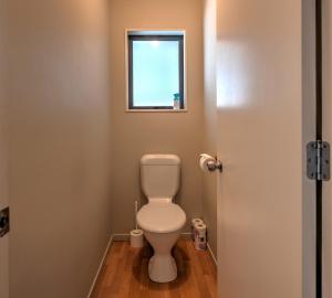 een kleine badkamer met toilet en raam bij 9a Tarndale Place in Hanmer Springs