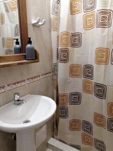 a bathroom with a sink and a shower curtain at Hostel Once Once in Villa de Leyva