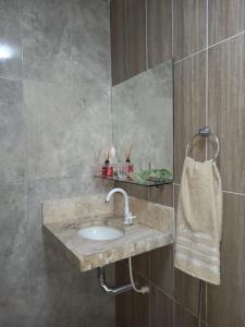 a bathroom with a sink and a mirror at Parque dos Coqueiros- Bangalos e Suites in Maragogi