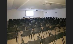 ein Zimmer mit einem Haufen Stühle und einem Bildschirm in der Unterkunft Maravilhoso apartamento tipo loft na Reserva do Sahy em Mangaratiba RJ in Mangaratiba + 26 Fotos