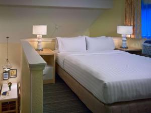 a hotel room with a bed and two tables and two lamps at AVIA on Mays Landing in Somers Point