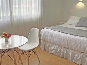 1 dormitorio con 1 cama, mesa blanca y silla en Novaqua Bed & Breakfast, en Olmué