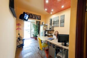 una mujer sentada en un escritorio con una computadora en Hotel-Hostel Mignon Mamaia -private rooms with free parking, en Mamaia