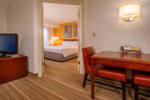 Habitación de hotel con cama, escritorio y habitación en Sonesta ES Suites Charlottesville University en Charlottesville