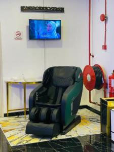 a reclining chair in a room with a tv at Hotel VGO in Kuala Lumpur