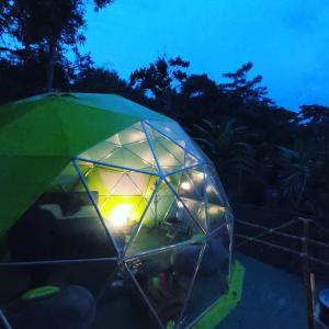 un iglú verde con luz por la noche en Glamping Dimensión Ecológica en Guateque