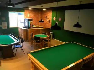 einen Billardtisch in einem Zimmer mit grünen Wänden in der Unterkunft Maravilhoso apartamento tipo loft na Reserva do Sahy em Mangaratiba RJ in Mangaratiba