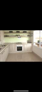 a kitchen with white cabinets and a sink and a window at Loft completo e refinado in Ribeirão Preto