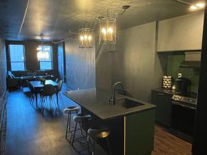 cocina con fregadero y mesa con taburetes en Luxury City Escape & Peaceful Retreat by Hollyhock en Louisville