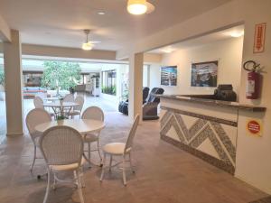 - un salon avec une table, des chaises et une cheminée dans l'établissement Praia Brava Hotel, à Florianópolis