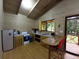 a kitchen in a log cabin with a wooden floor at Cabinas Costa Tropicana in Uvita