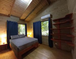 ein Schlafzimmer mit einem Bett in einem Blockhaus in der Unterkunft Cabinas Costa Tropicana in Uvita