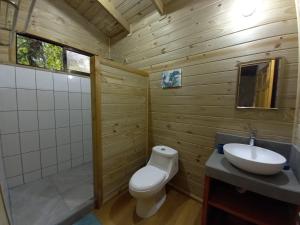 a bathroom with a toilet and a sink at Cabinas Costa Tropicana in Uvita