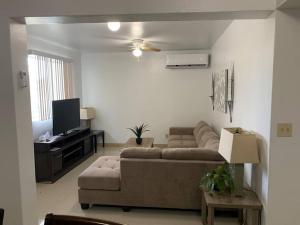 a living room with a couch and a tv at Private/Central 3 Bedroom Home in Hagatna