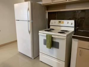 eine Küche mit einem weißen Herd und einem Kühlschrank in der Unterkunft Private/Central 3 Bedroom Home in Hagatna