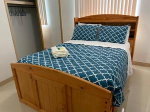 a bed with a blue comforter and two towels on it at Private/Central 3 Bedroom Home in Hagatna