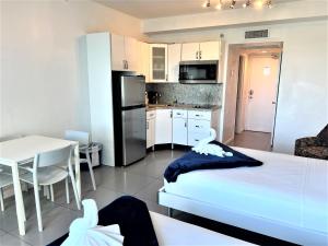 a room with a bed and a kitchen with a table at Ocean Front Units at Miami Beach in Miami Beach