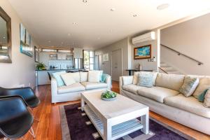 a living room with two couches and a table at The Sands - Villa 28 in Onetangi