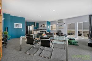 a dining room with a glass table and chairs at QV Stays Stunning Downtown Executive Penthouse in Auckland