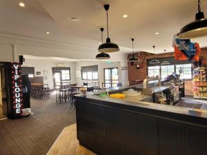 a restaurant with a counter and some chairs and tables at Palm and Pawn Motor Inn in North Wagga