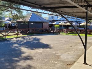 um parque de estacionamento vazio com uma cerca e um edifício em Palm and Pawn Motor Inn em North Wagga