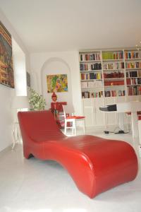 a red couch in a living room with bookshelves at VitaminaM in Turin