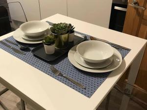 a table with two plates and bowls on a tray at Serviced Appartment 1 Helena in Reading