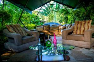 a patio with two couches and a table with a bottle on it at Jaja's One Bedroom near Ciala Resort Kisumu in Kisumu