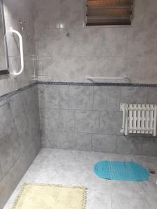 baño con ducha y alfombra azul en Complejo Solar Apart en Villa Regina