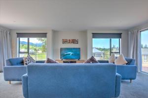 a living room with two blue couches and a tv at 49 St James Avenue in Hanmer Springs