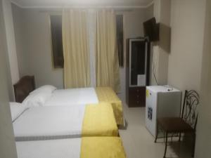 una camera d'albergo con due letti e una televisione di Hotel Premier Inn a Manta
