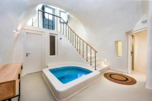 a bathroom with a tub in the middle of a staircase at Hill Suites in Fira