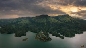 an island in a body of water with mountains at MOUNTAIN SHADOWS RESORTS in Wayanad