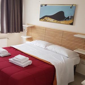 een slaapkamer met een rood bed en handdoeken erop bij B&B Soriano44 in Napels