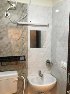 Hotel White Fields Hitec City, Hyderabad في حيدر أباد: حمام مع حوض ومرحاض ومرآة