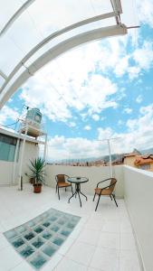 patio con mesa y sillas en el balcón en Arcopata Apartamentos, en Cusco