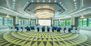 a large room with a stage with chairs and a presentation at Grand Park Kunming in Kunming +23 photos