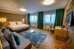 a hotel room with a bed and a couch at AZIMUT Hotel Siberia in Novosibirsk