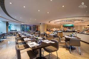 a restaurant with tables and chairs and a bar at Grand Park Kunming in Kunming