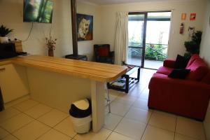 uma sala de estar com um balcão e um sofá vermelho em Eungella Cabins em Eungella