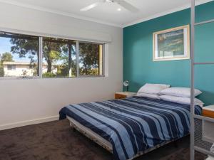 1 dormitorio con cama y ventana en 23 Lewis Road, en Carrickalinga