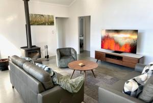 a living room with a couch and a tv and a table at Villa Vines @ Rivendell Winery Estate in Yallingup Siding
