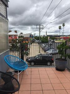 einen Balkon mit einem blauen Stuhl und einem Auto auf einer Straße in der Unterkunft Central Motel Mudgee in Mudgee