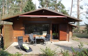 a cabin with a table and chairs in front of it at Ortheide 68 in Böddenstedt