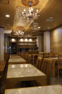 a restaurant with wooden tables and chairs and a chandelier at Thai Cozy House in Bangkok