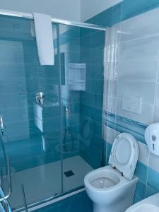 a blue bathroom with a toilet and a shower at CapriOnda in Capri